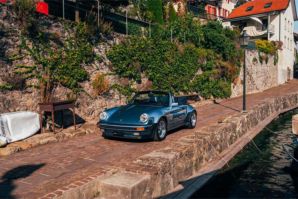 PORSCHE 911 3.2 Turbo Look usine Cabriolet bleue grise au bord d'un petit port