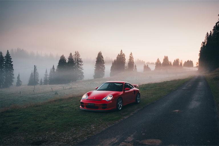 PORSCHE 911 type 996 GT2 Clubsport rouge sur un chemin bordé de sapins